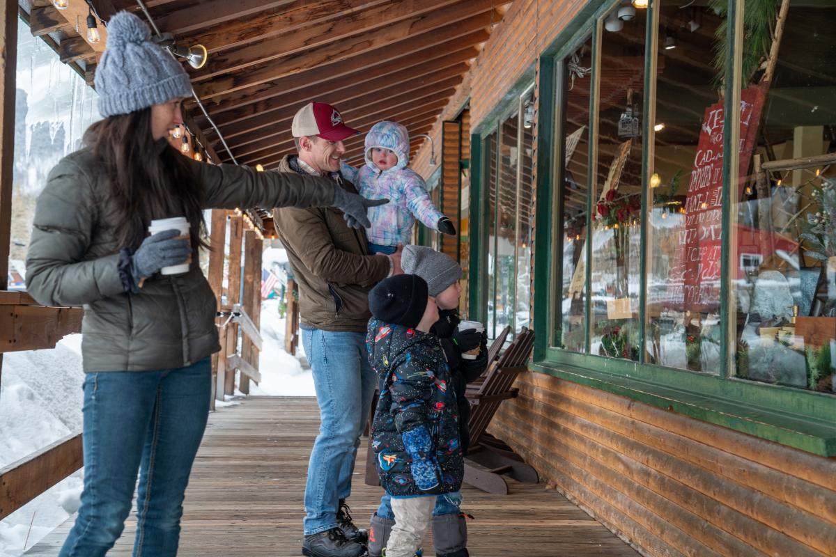 A family window shopping on the boardwalks of Grand Avenue in Grand Lake