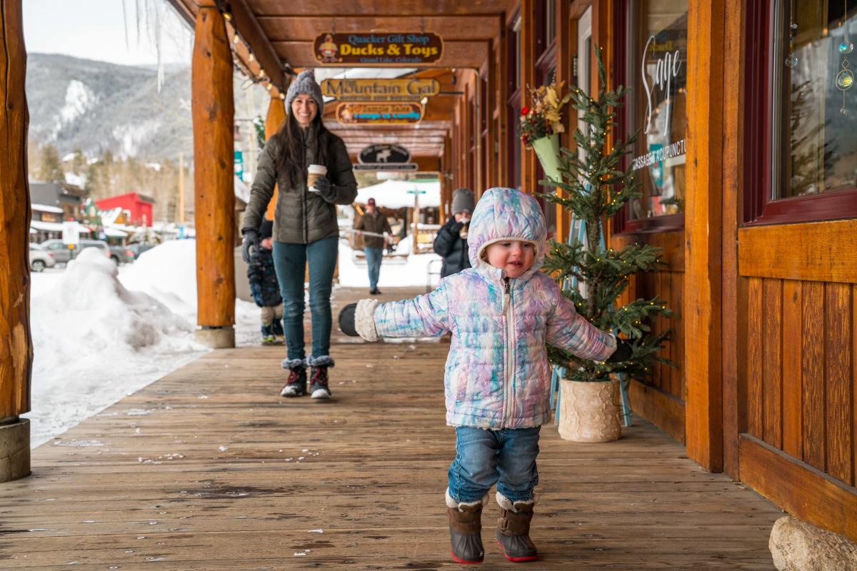 A little girl dressed for winter runs ahead of her family on the boardwalk in Grand Avenue