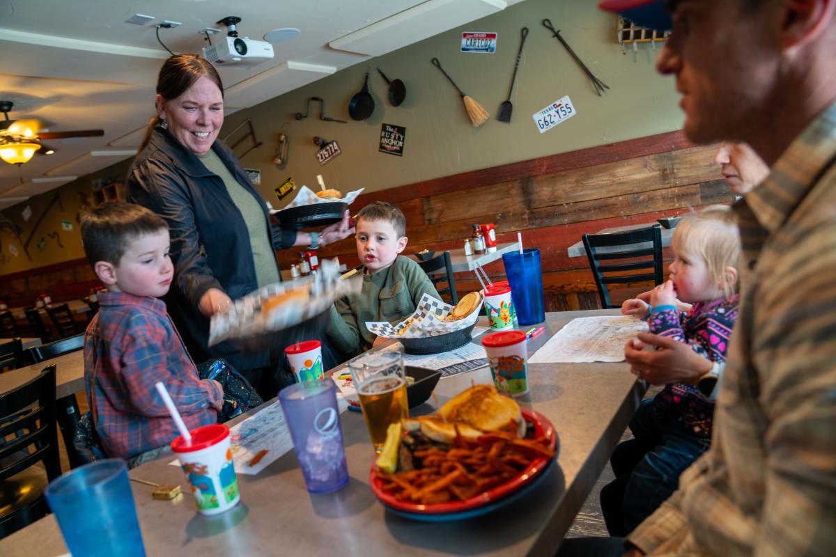 A waitress delivers food to a table in a restaurant in Grand Lake