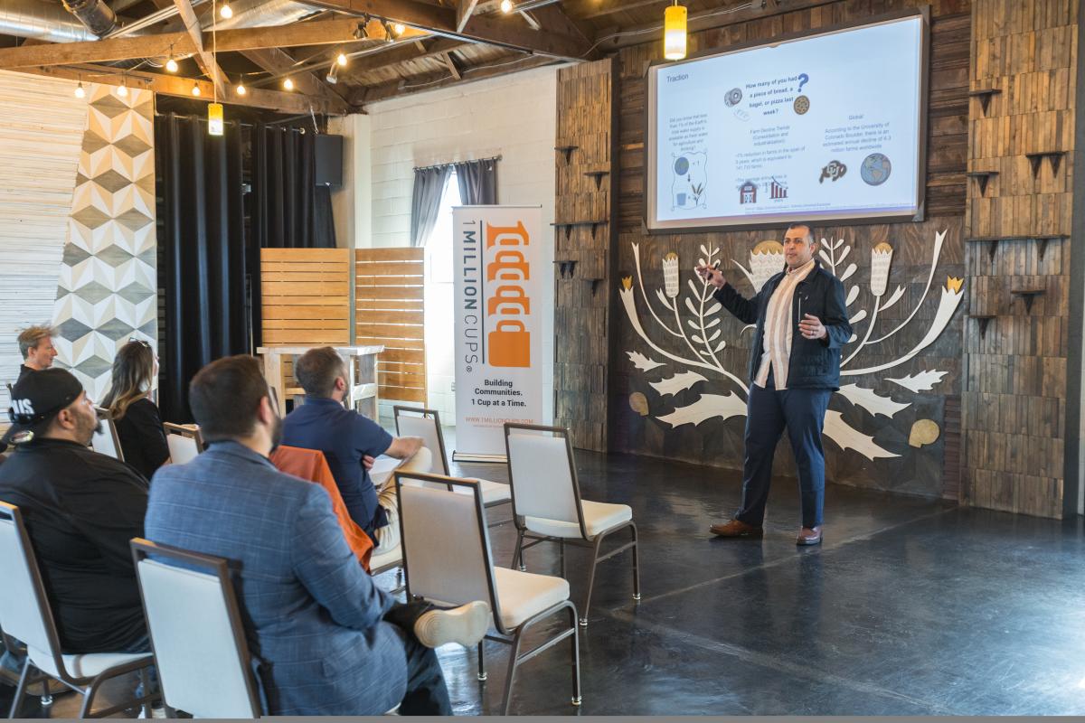 Business owner presents his pitch deck at the Atlas Theater to a group of other business owners during a 1 Million Cups event.