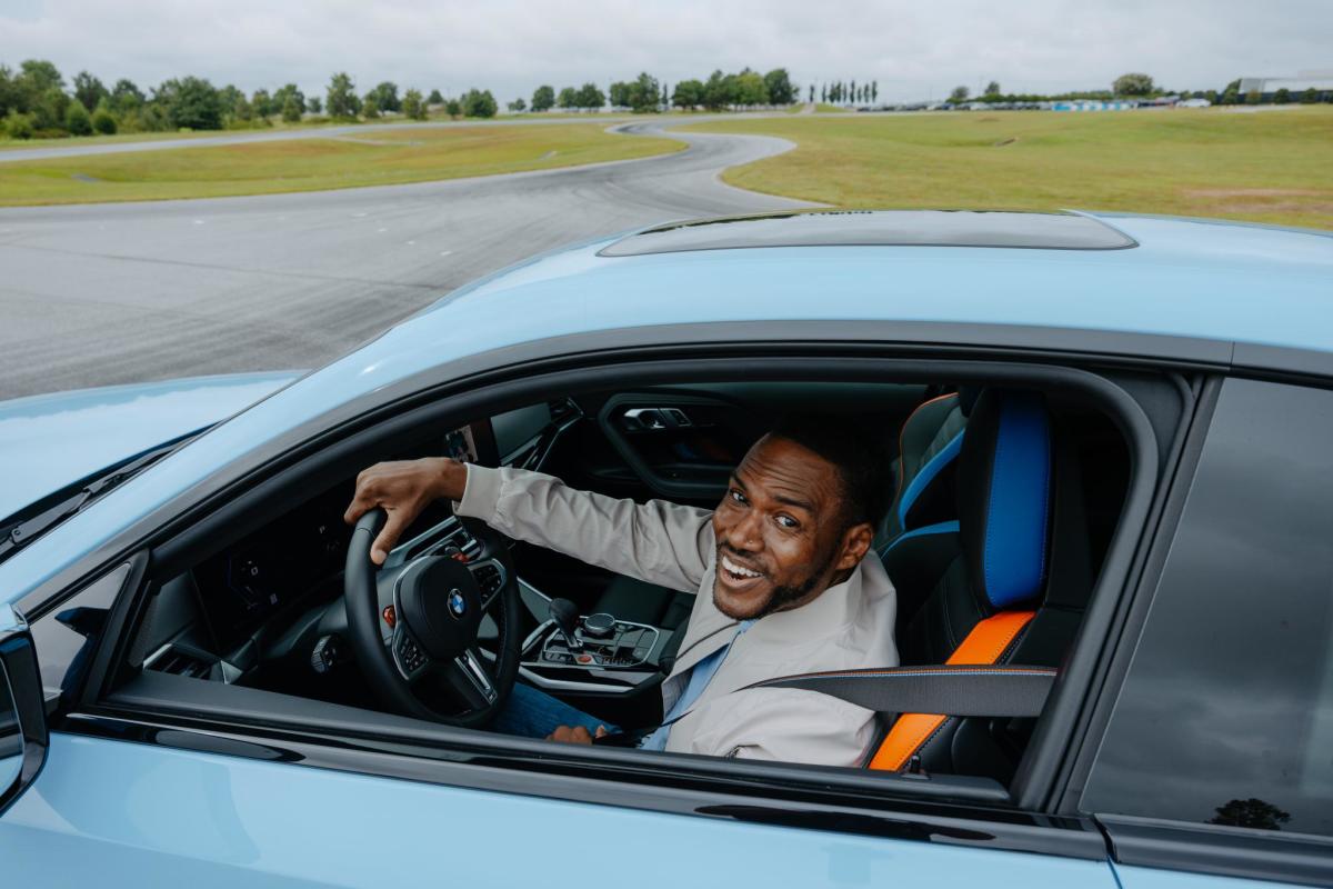 A man smiles happily driving a BMW as part of the BMW Performance Drive at the BMW Performance Center in Greer, SC.