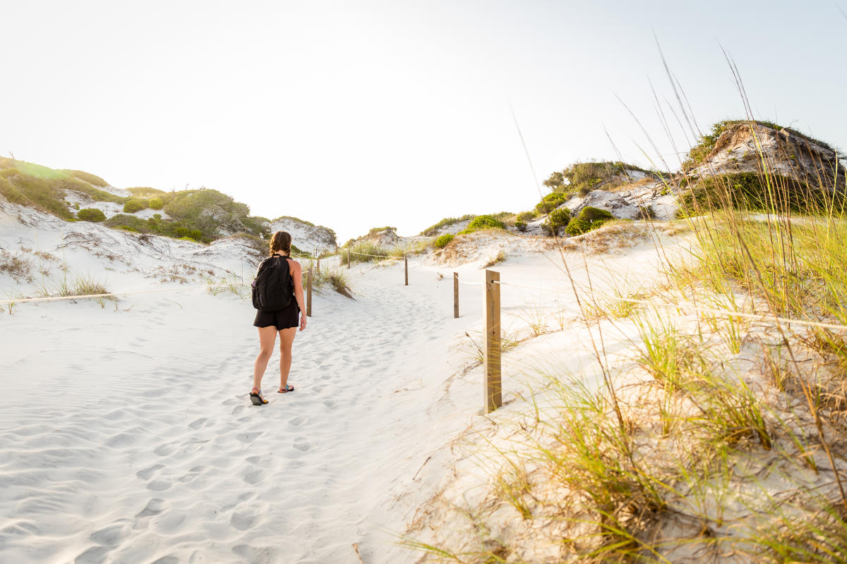 A woman dressed in black hikes alone through the massive sand dunes in the State Park