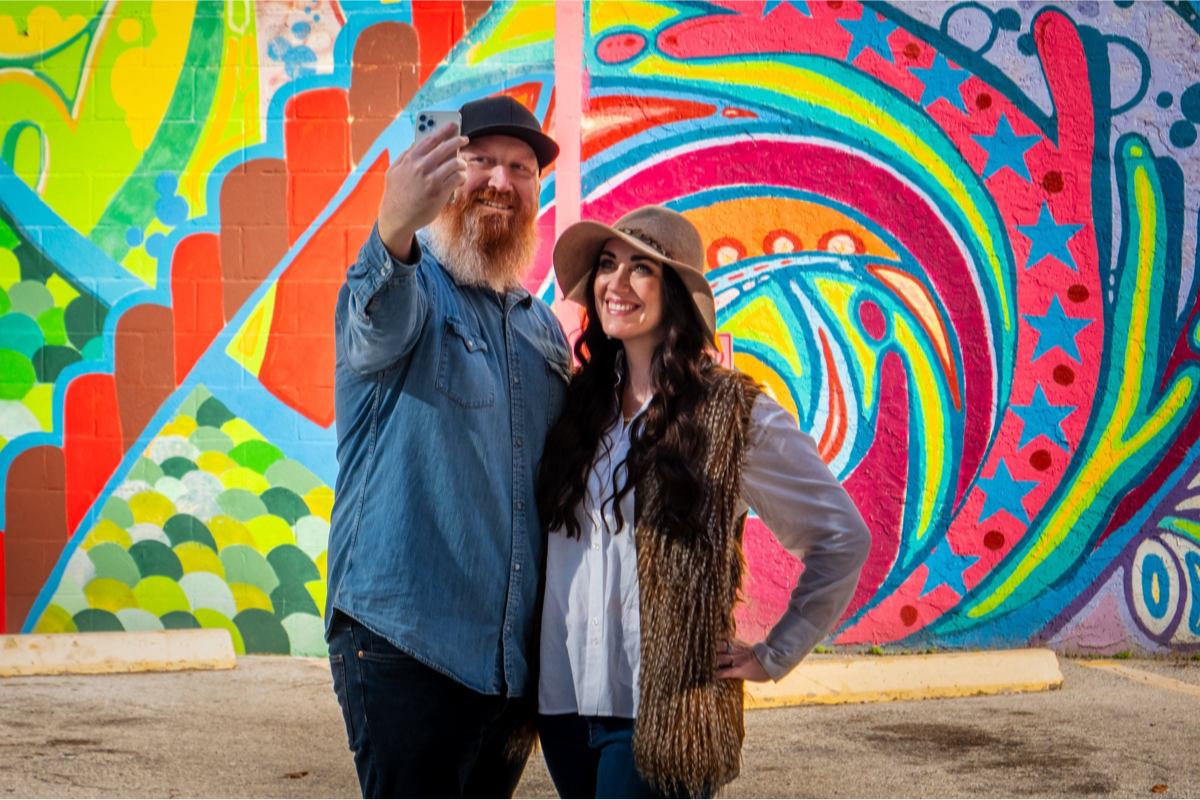 Couple taking a photo in front of a Houston mural