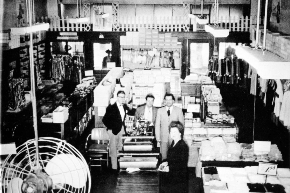 Sol Schulman and staff standing among clothing racks and display tables inside Schulman’s Department Store in Sylva, NC, in the 1940s