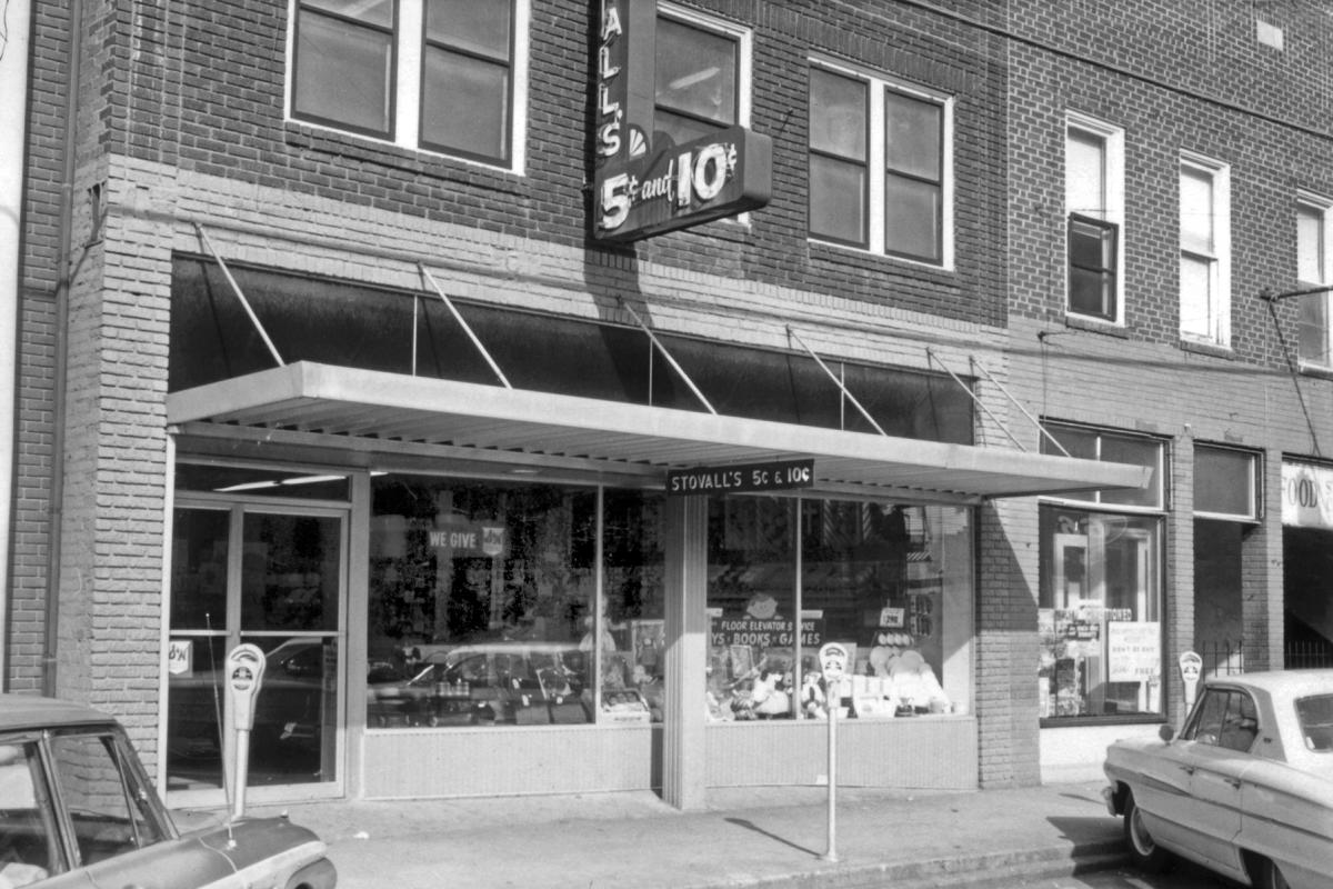 Stovall’s 5 & 10 dime store on Main Street in Sylva, NC, with a neon sign, metal awning, toys in the windows and parking meters out front