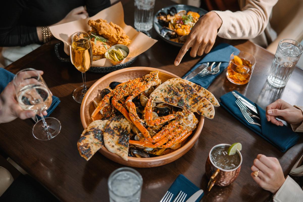 A platter of seafood sits in the middle of a dark wood table at Brick and Brine.