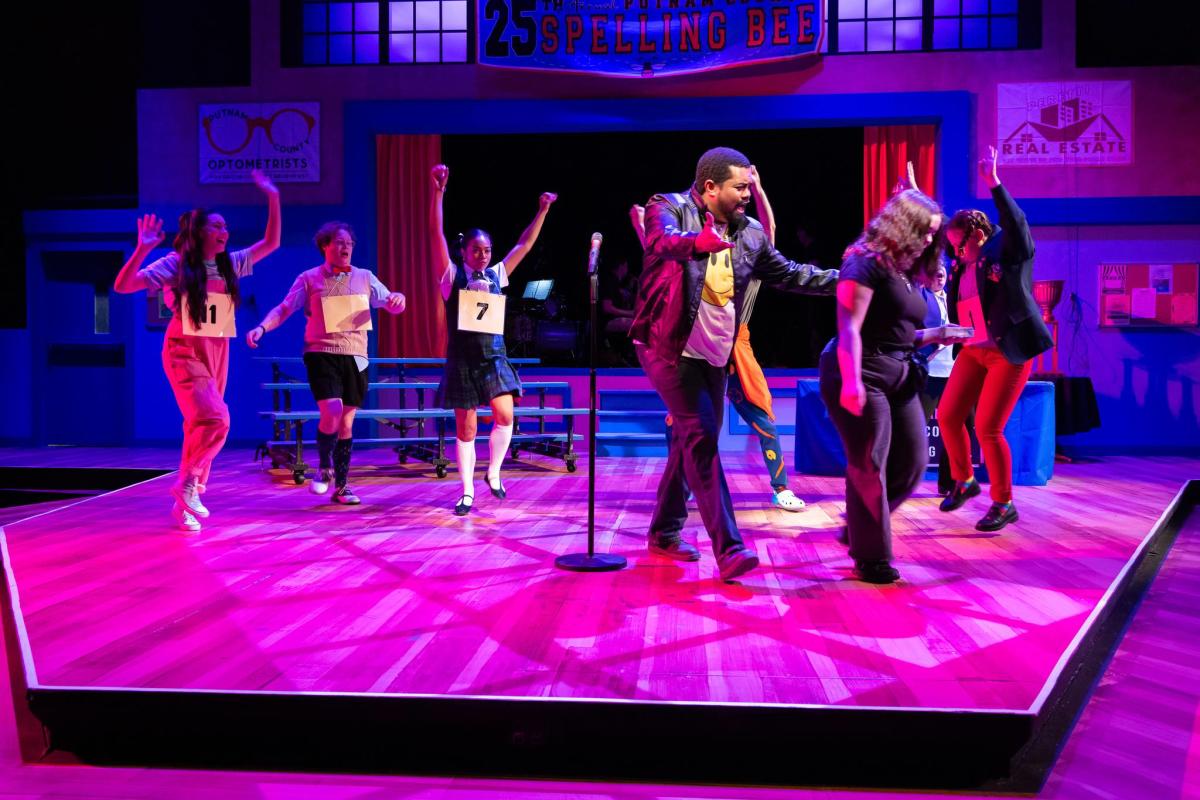 A man and group of dancers perform on stage at Farmers Alley Theatre.