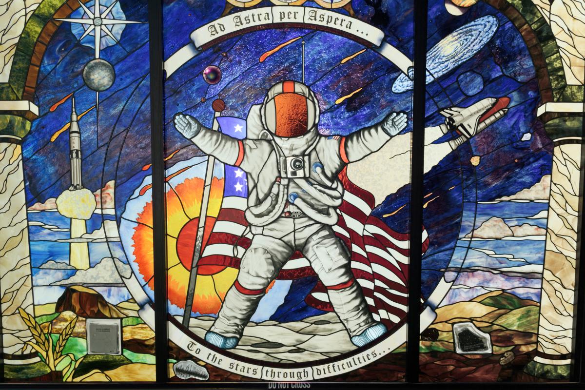 stained glass mural of an astronaut in the center, space themed