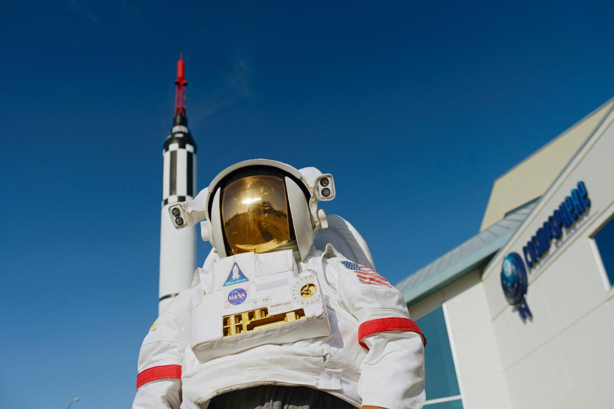 looking up at an astronaut in front of a space museum