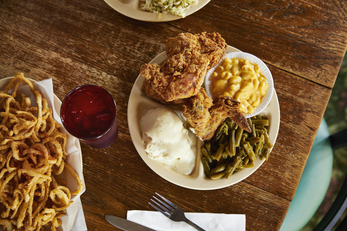 Fried chicken, mashed potatoes, mac and cheese and green beans served on a plate at Chicken Mary's