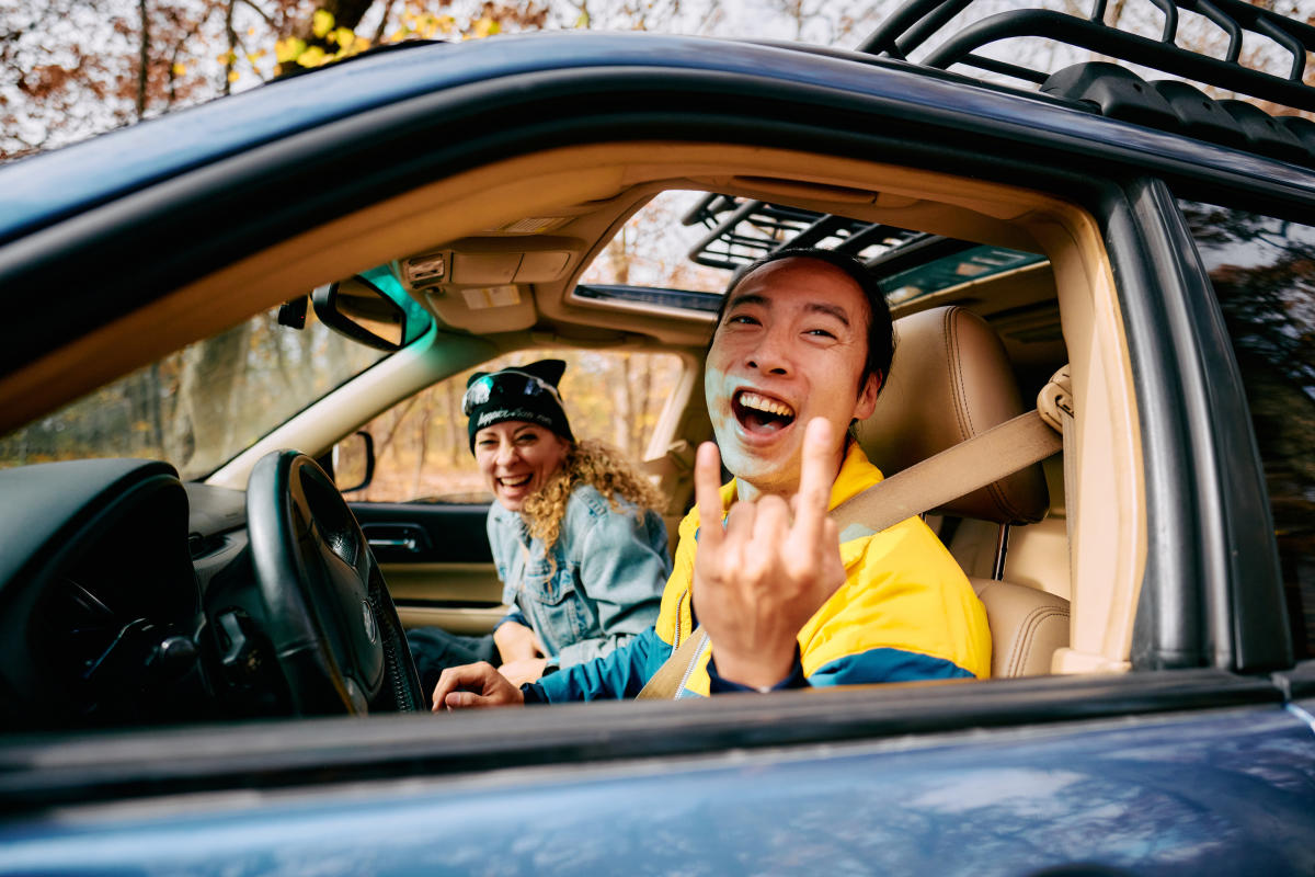 Man holds up rock-on sign in the driver's seat of a car at KanRocks Recreation Area