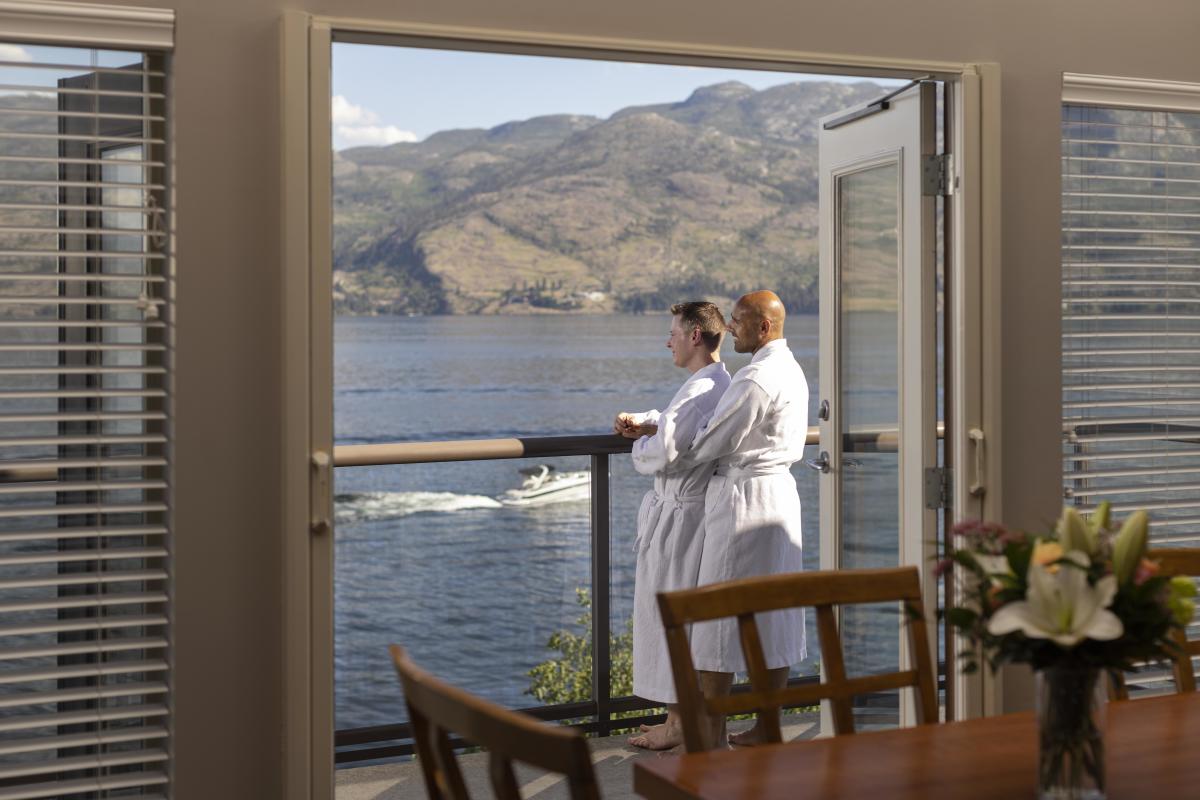 A couple overlooking the water from their balcony at The Cove Lakeside Resort
