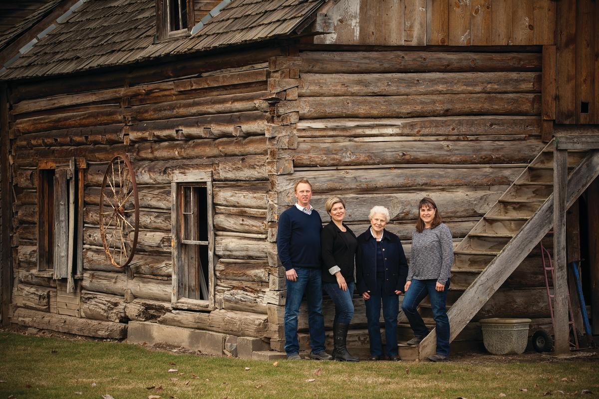 A family standing in front of an old wooden building