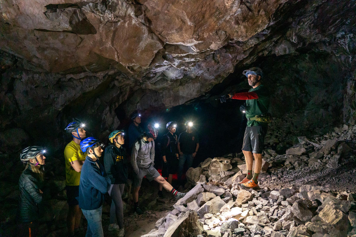 Group of bikers listen to presentation about bats underground at Adventure Mine