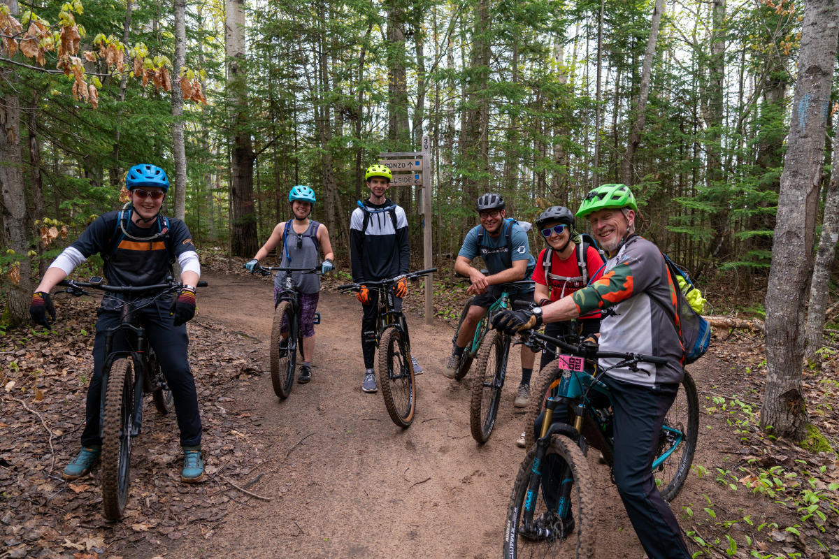 Smiling bikers pause for a photo on Keweenaw trail.