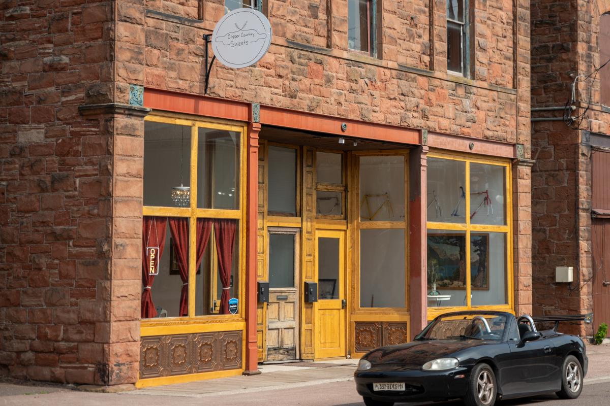 red historic sandstone building with a sportscar parked in front