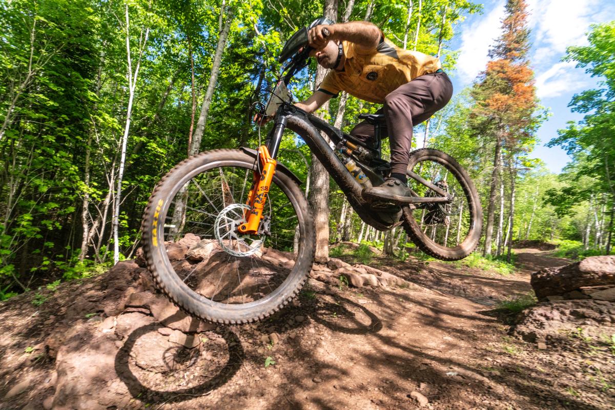 mountain biker catches air off a dirt path
