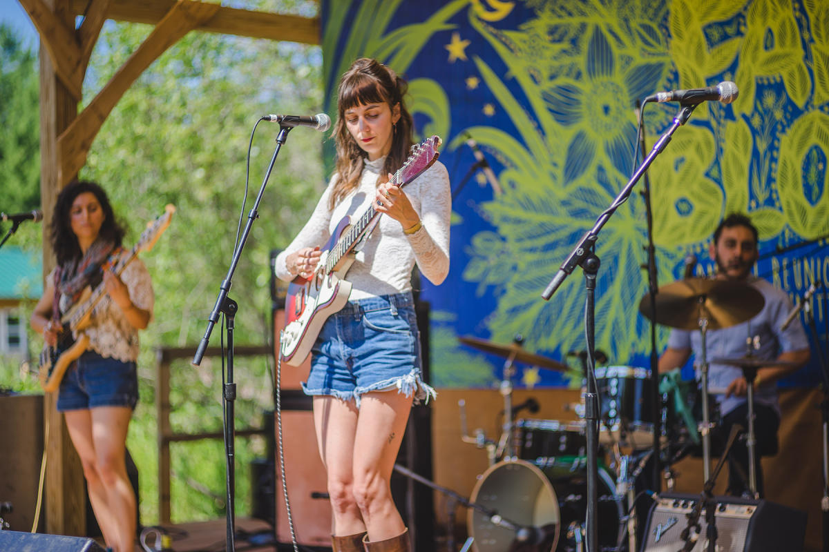 Woman plays guitar on stage at music festival