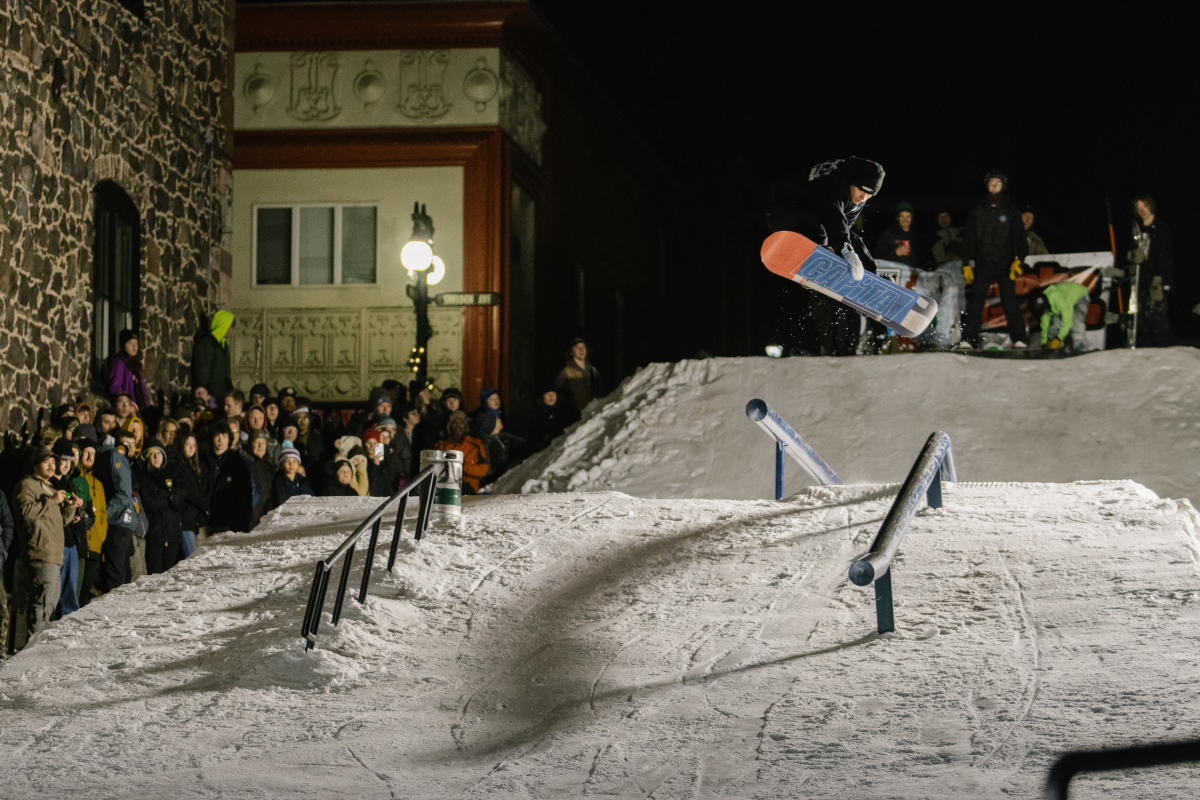 a snowboarder catches air in a downtown snow feature