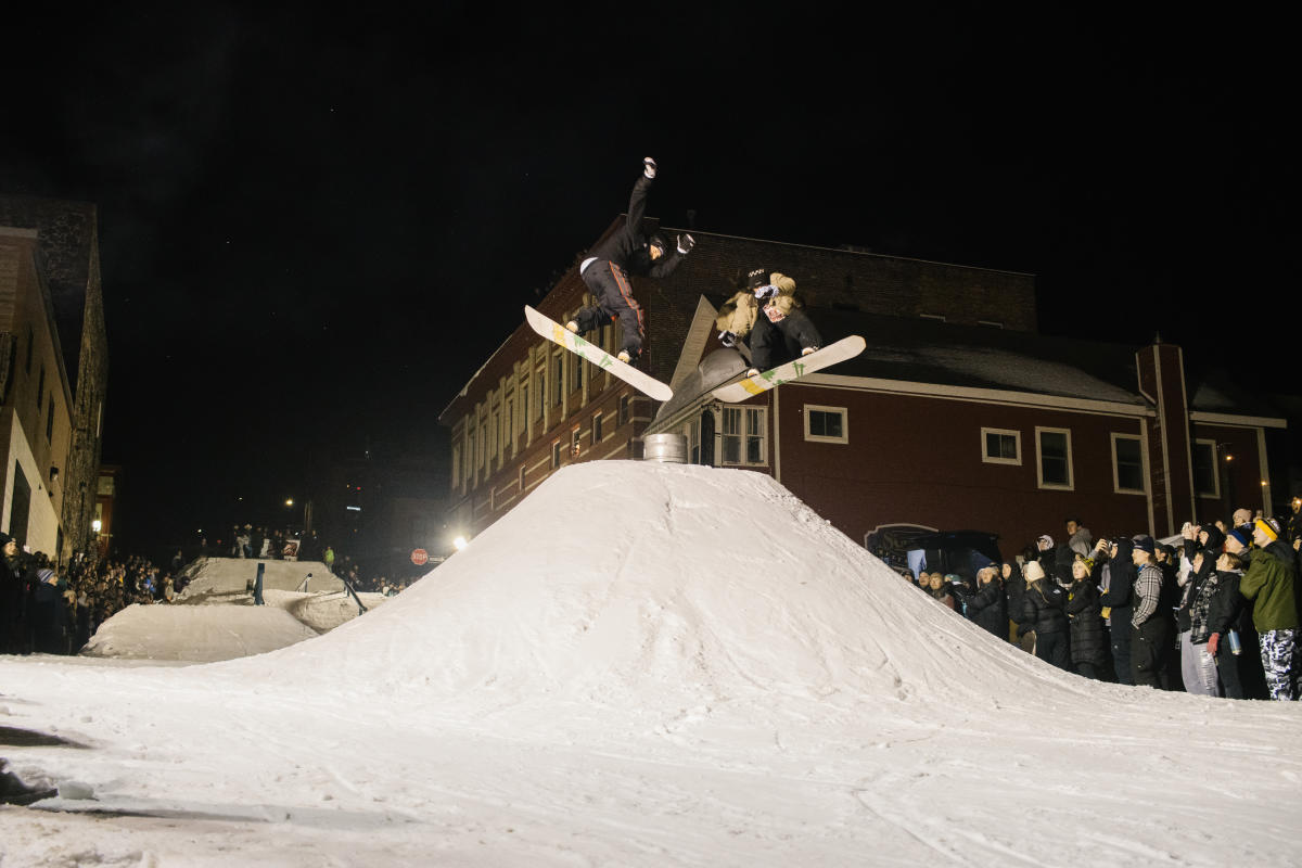 Two snowboarders perform a trick during Jibba Jabba Rail Jam.