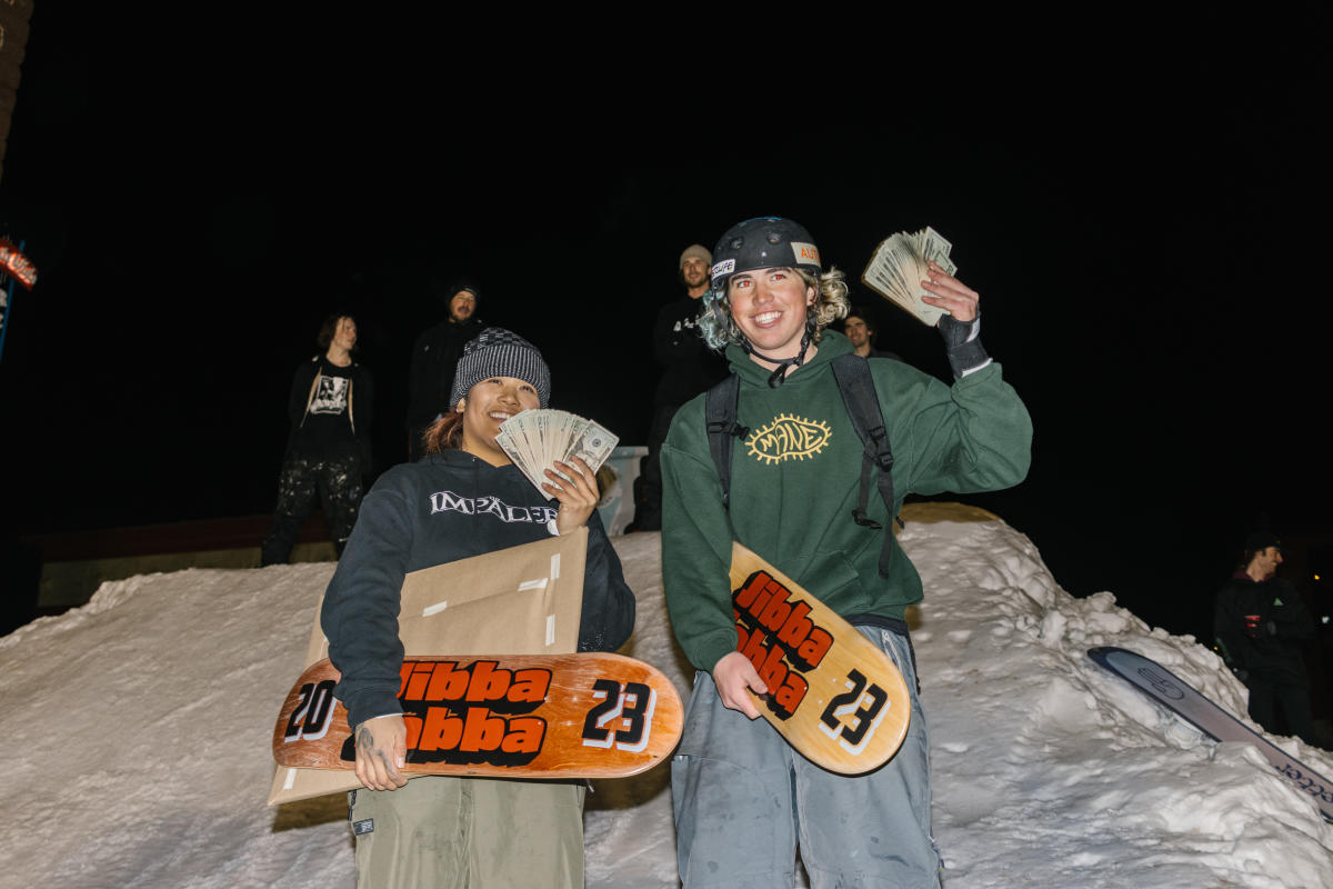 Two competitors hold their cash prize for a photo.