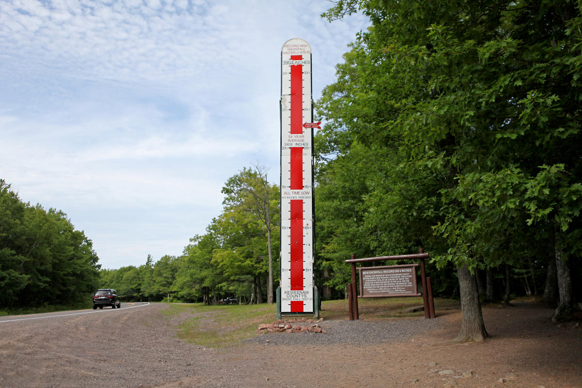 Tall thermometer like gauge displaying snowfall totals for Keweenaw county.