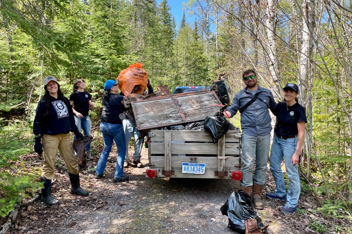 Volunteers pose for a picture with trailer of trash collected during a KORC clean up event.