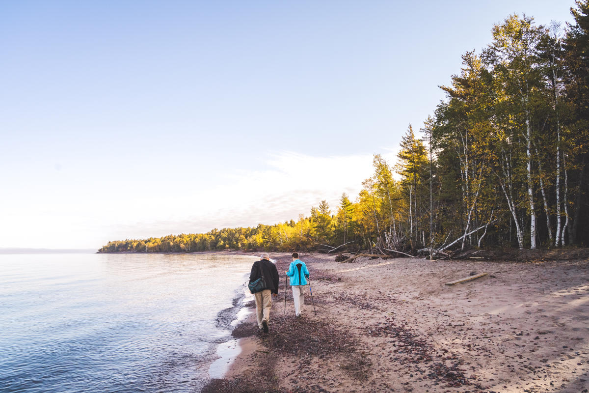 A couple walking along the shore of McLain State Park Beach