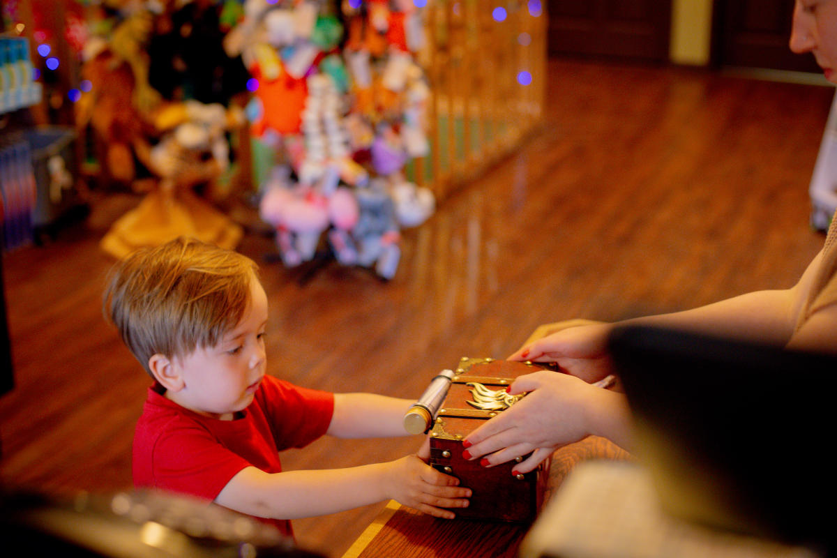 a child receives a purchase over the counter in a toy store