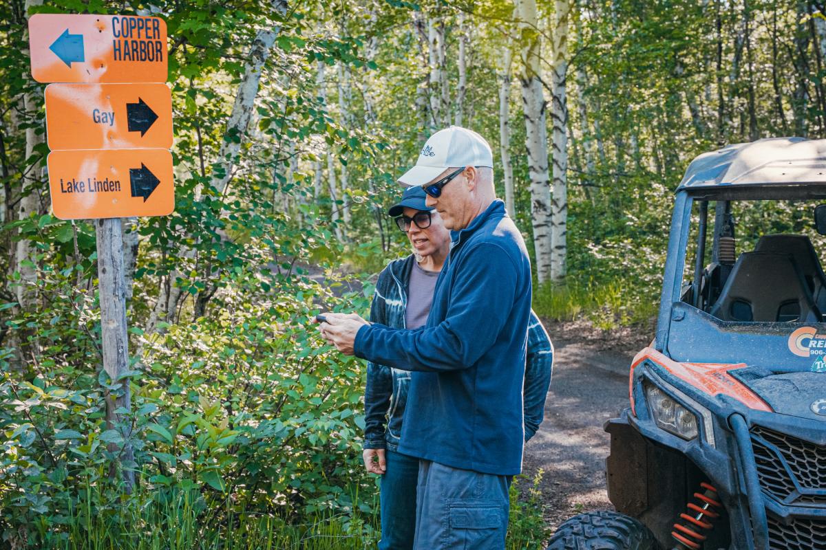 Two people use their phone to plan their route.