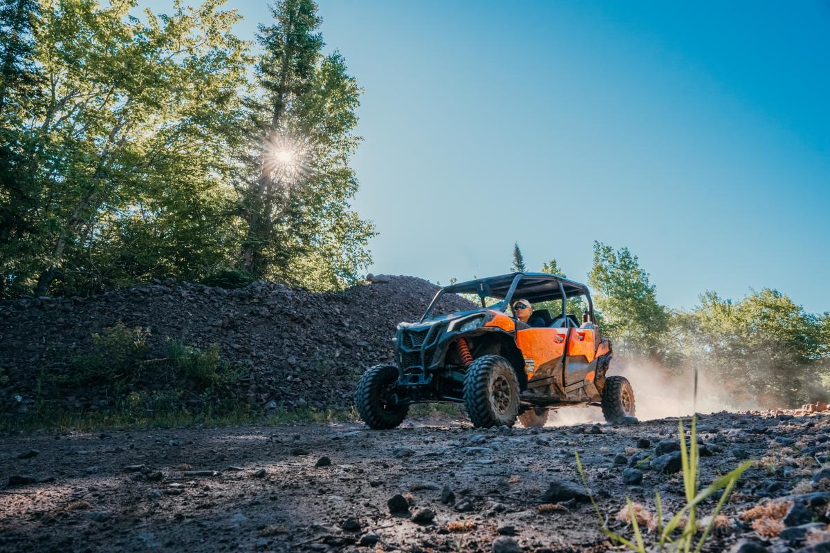 An orange side-by-side cruises down Keweenaw ATV trails.