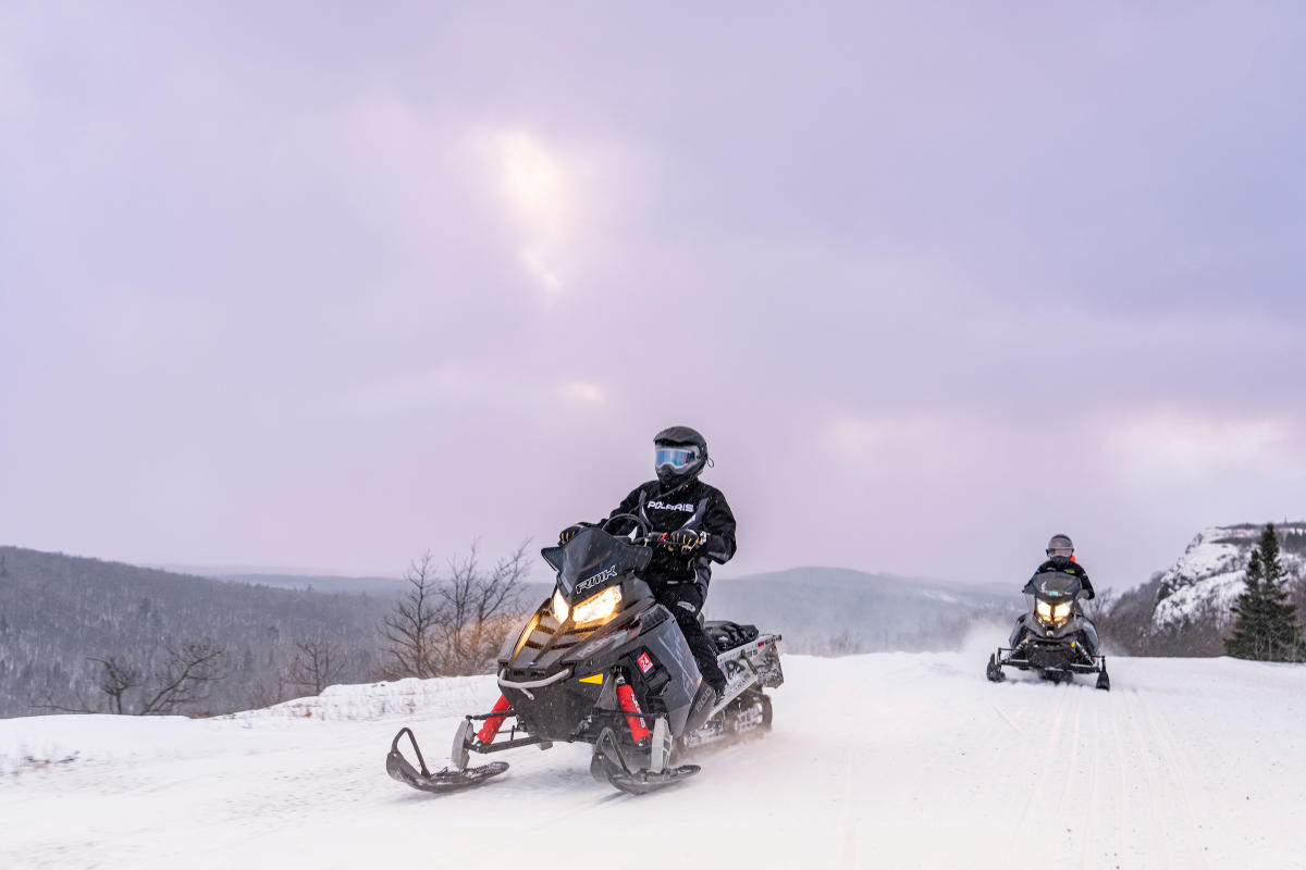 Two snowmobilers riding Brockway Mountain Trail.