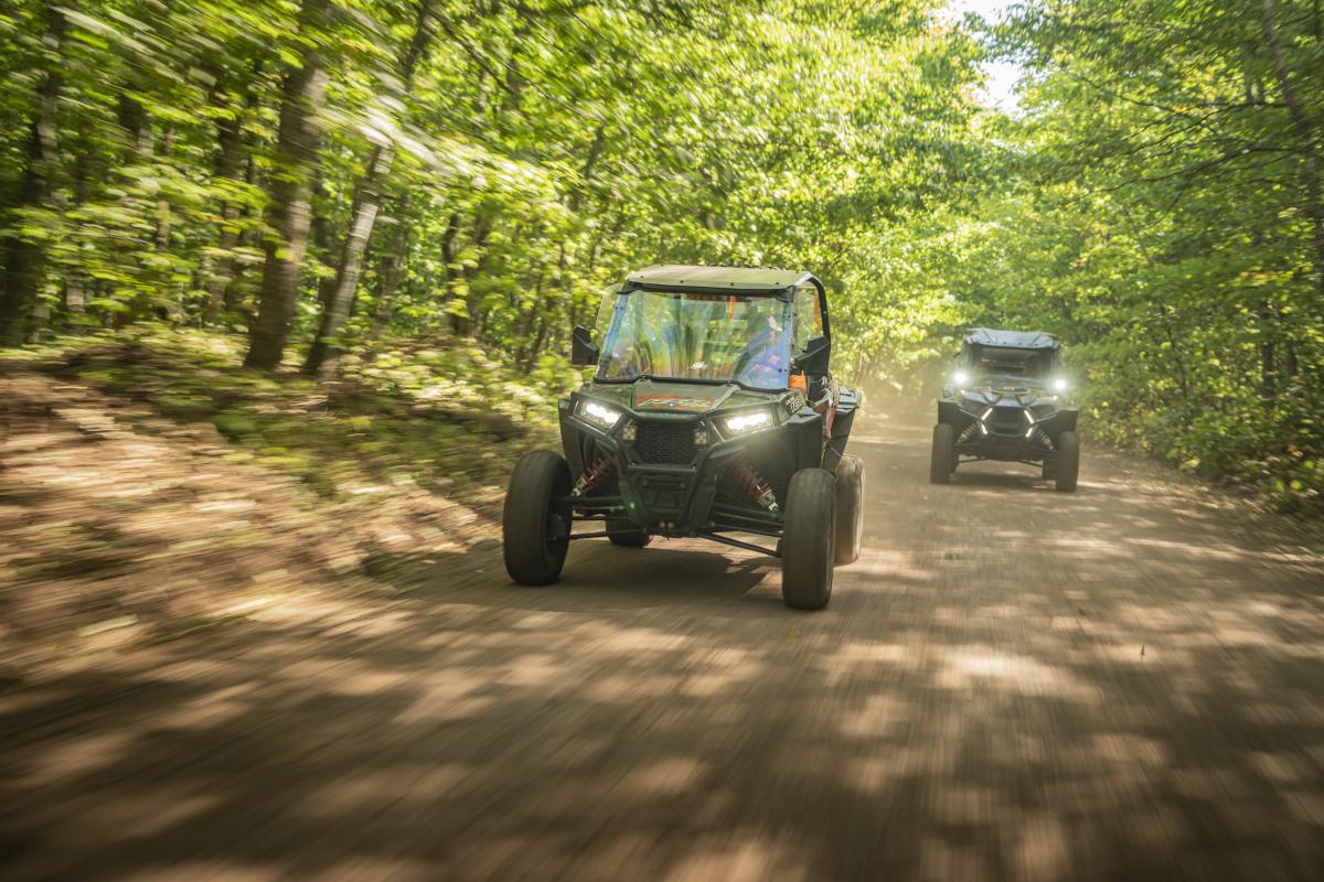 Two SxS's follow trail through Keweenaw forest.