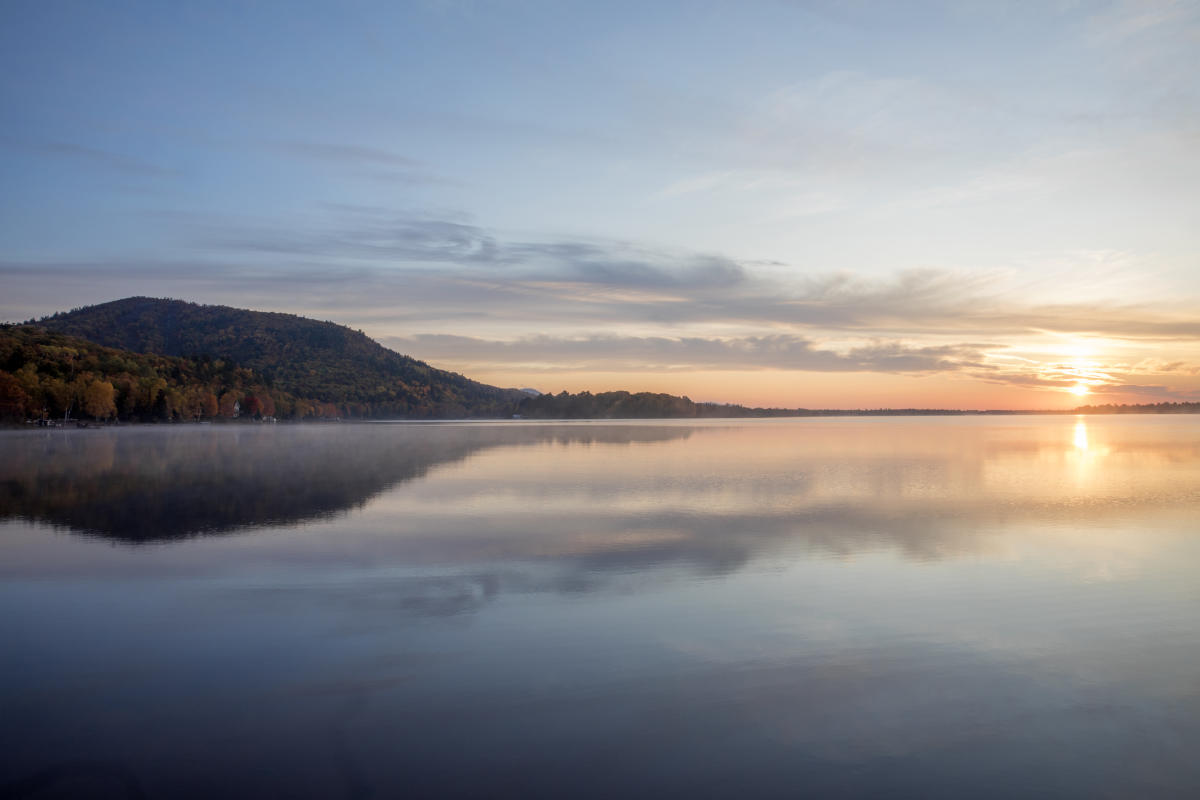 Foggy sunrise on Lac La Belle with mountain in background.