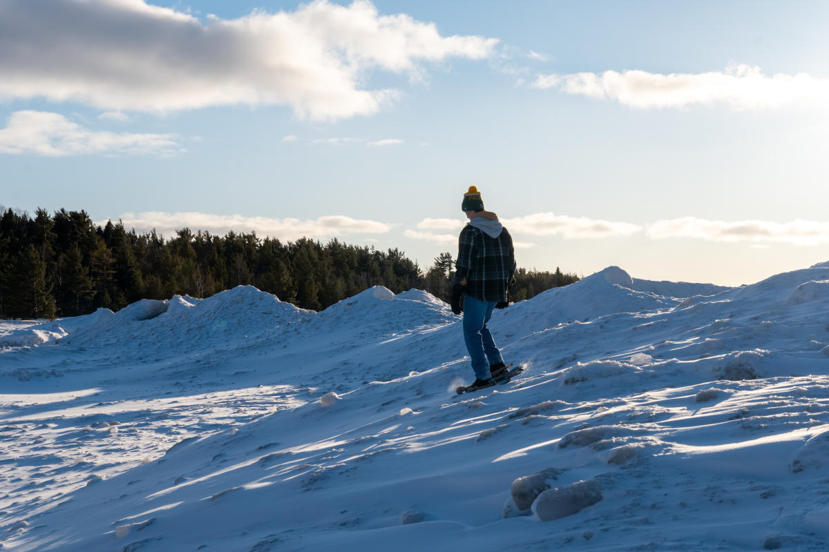 Snowshoer hikes along frozen ice volcanoes.