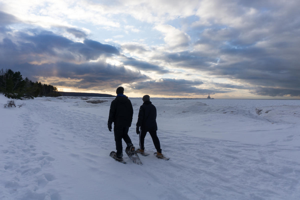 Two snowshoers on the icy shore of Lake Superior