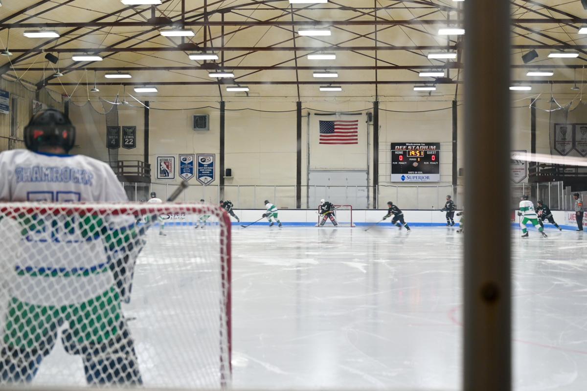 a hockey goalie defends a net