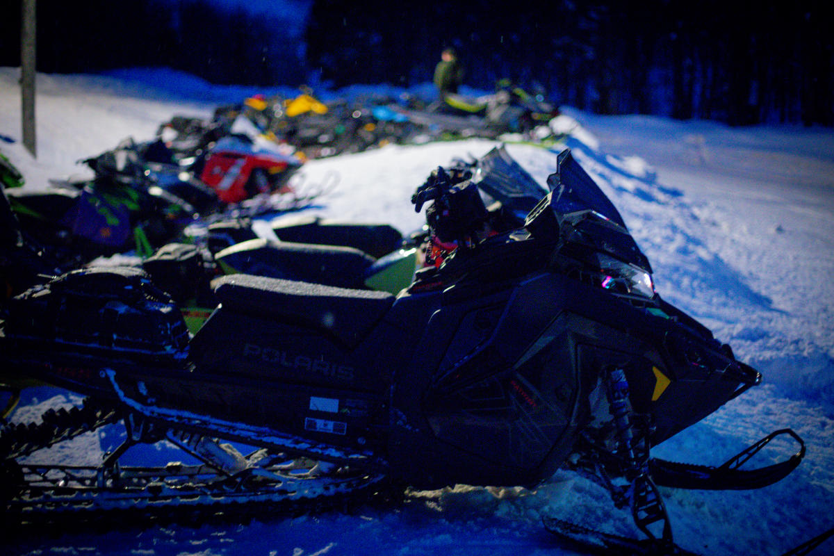 snowmobiles sit in the snow