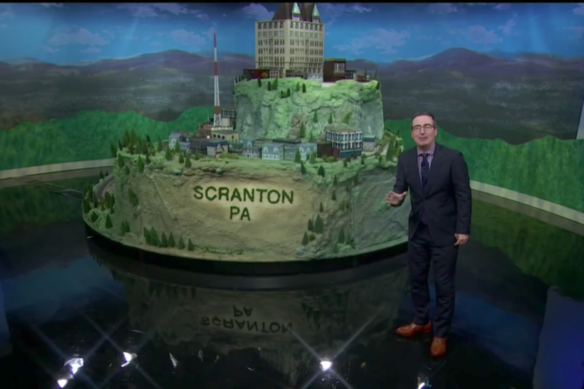 John Oliver standing in front of the Scranton train set.