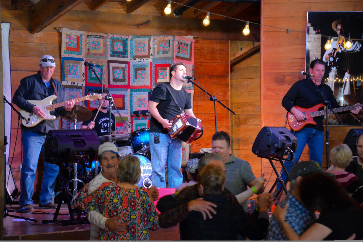 A band performing on stage at the Vermilionville Performance Center