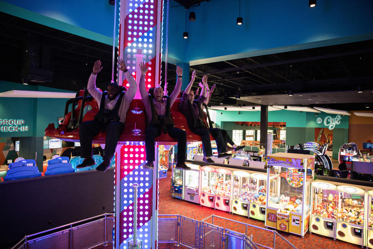 interior drop zone, neon lights, arcade, hands in the air