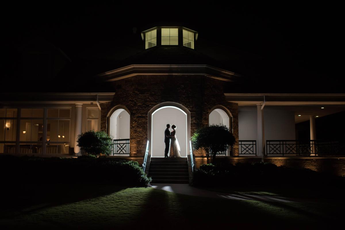 A silhouette of a bride and groom under an arch