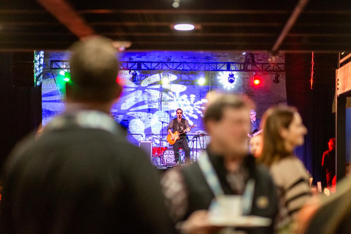 Live concert at Grewal Hall in Lansing, with an energetic crowd enjoying a performance. The modern venue is filled with vibrant lights and music, creating an unforgettable atmosphere for music lovers and visitors alike.