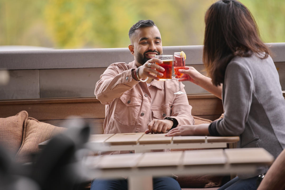 Two people clinking glasses together