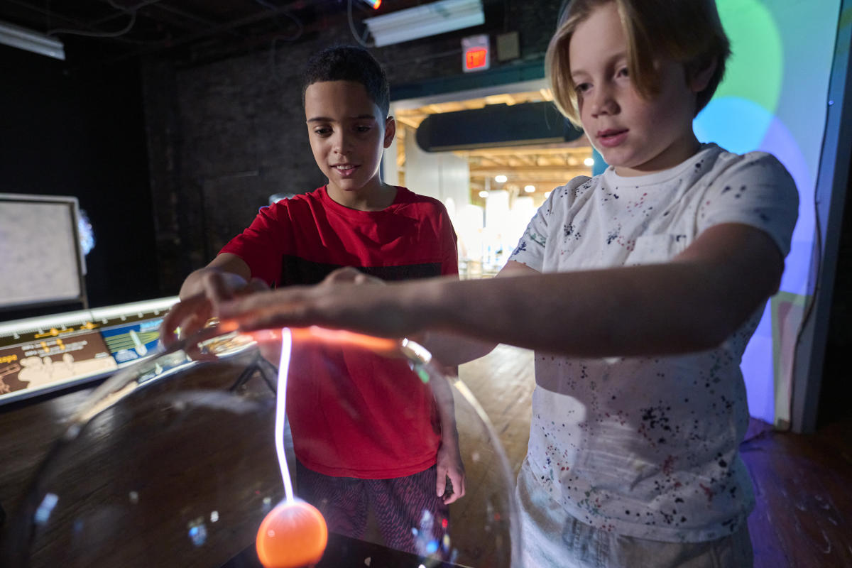 Two boys touching the electric globe