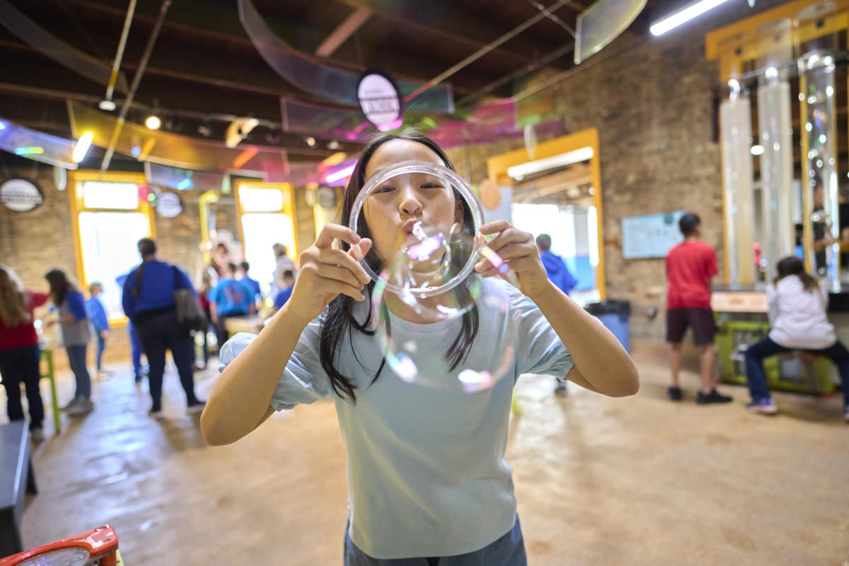 Young girl blowing bubbles at Impression 5