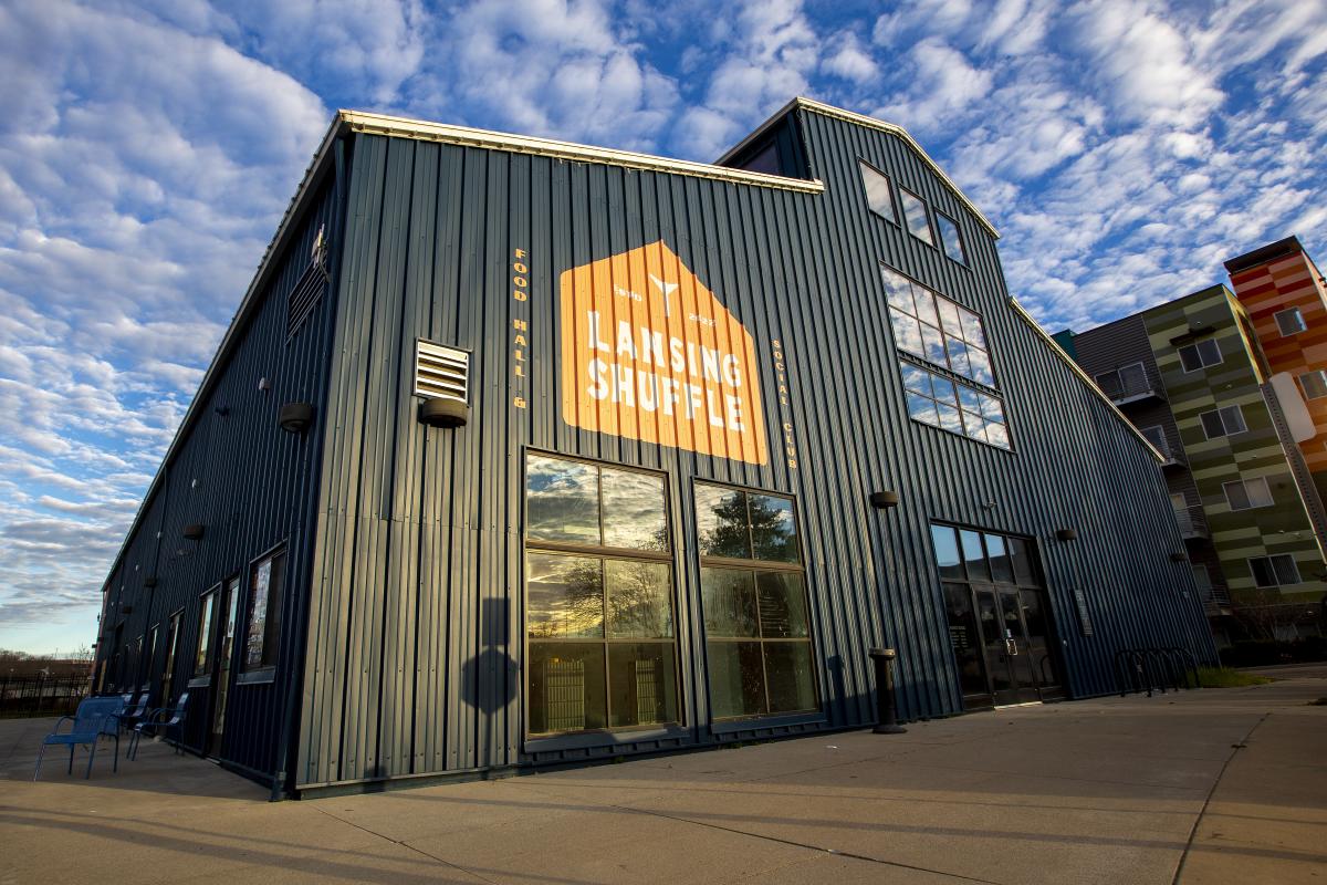 Exterior of a large dark blue building with a log that reads "Lansing Shuffle."