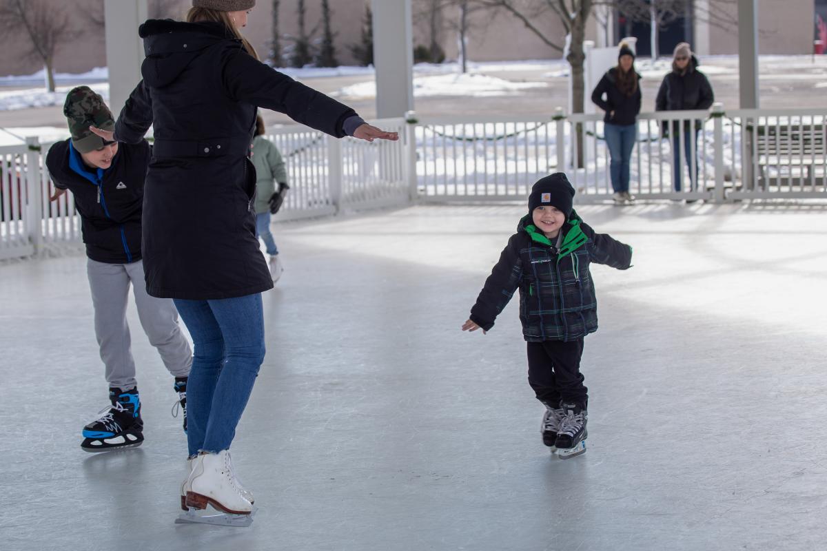 Child staking at the Meridian Skating Rink with his family