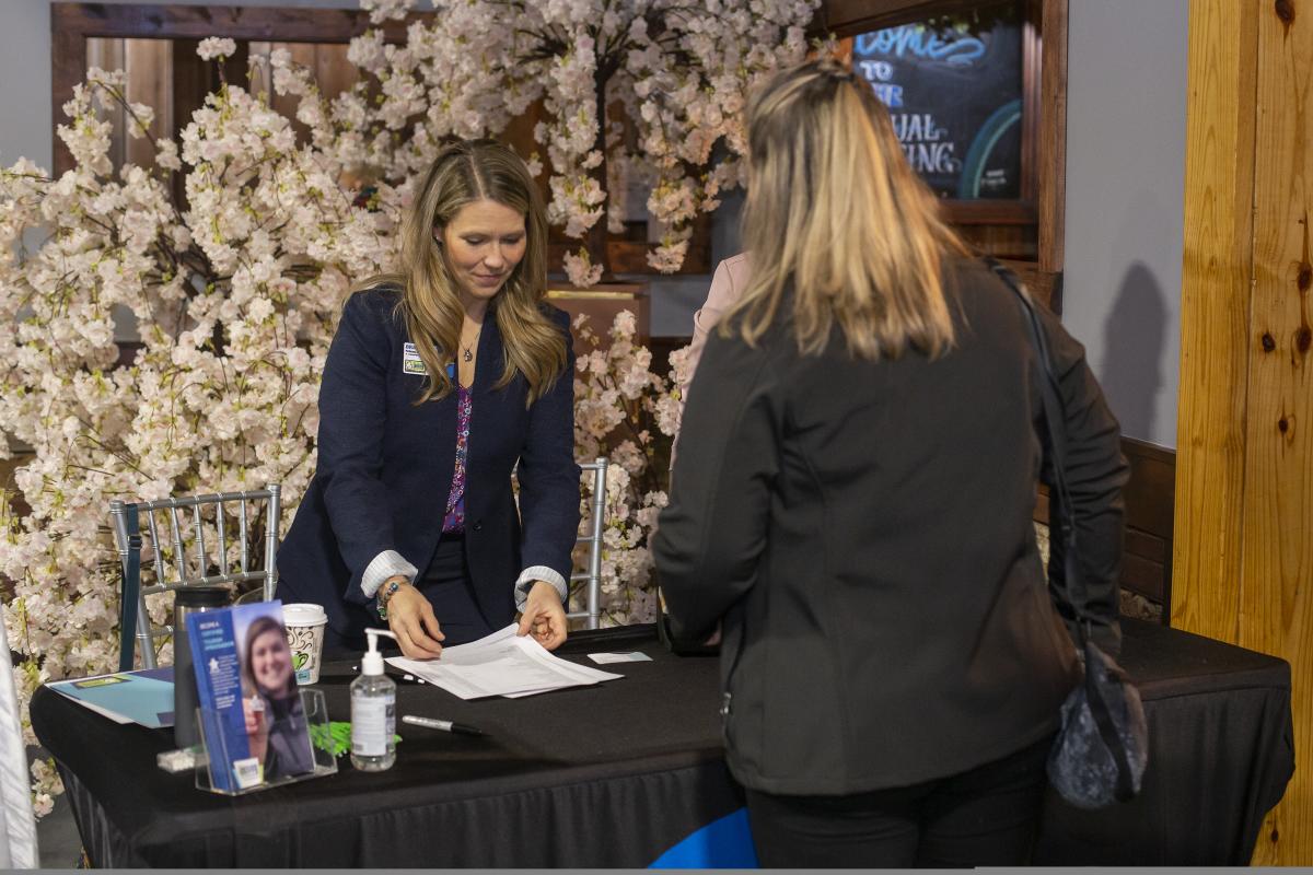 Meeting professional checking in someone at registration.