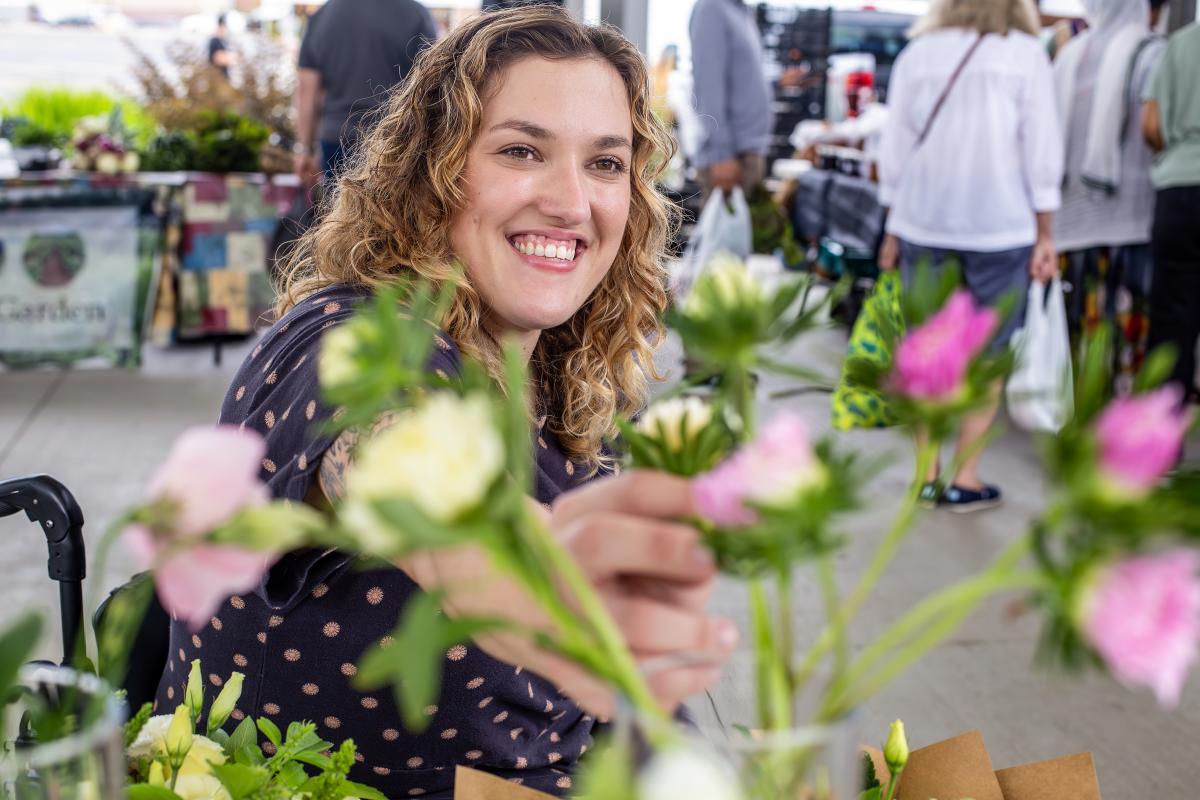 Sara reaches over to look at some flowers